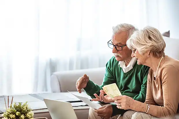 an old couple looking at a laptop